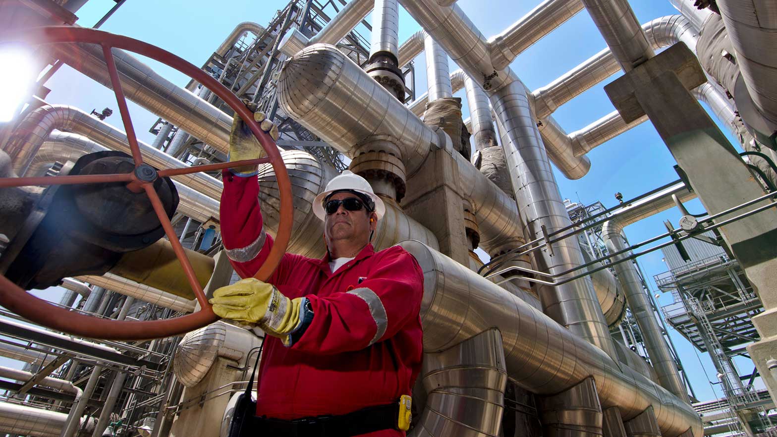 a chevron employee turning a wheel that opens a pipe