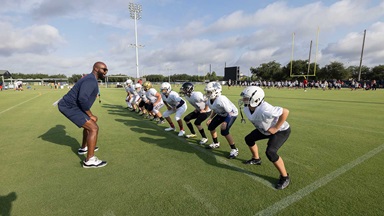 coach of a football team gives directions during practice